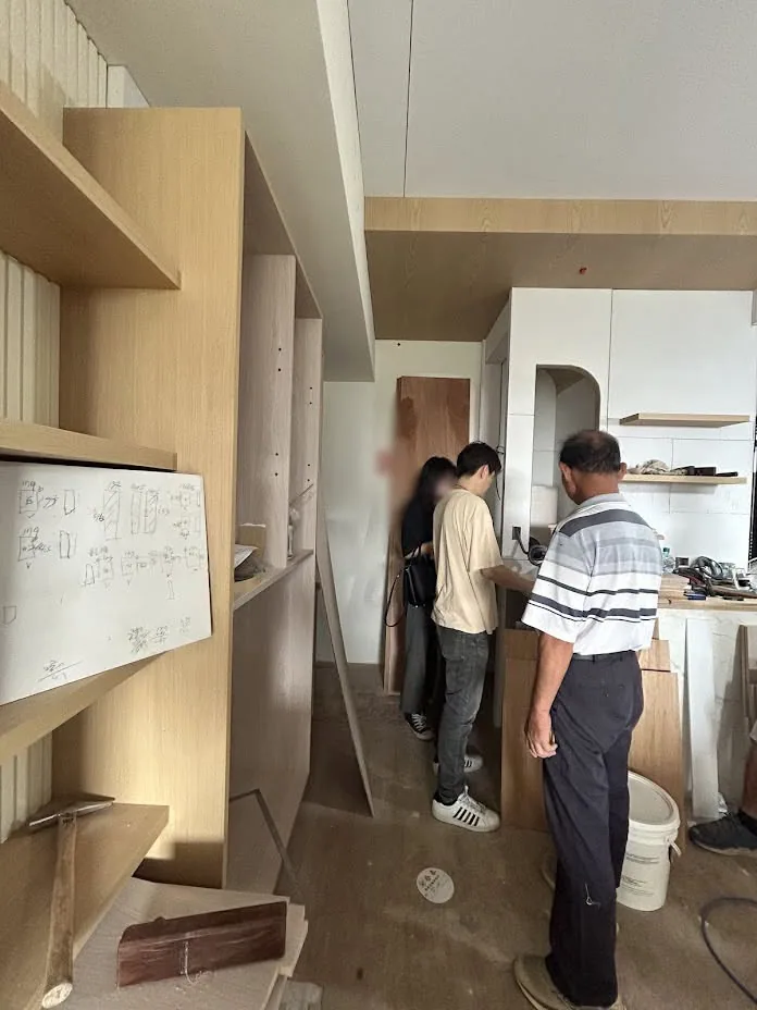 施工人員手持滾筒於室內牆面進行油漆塗裝施工作業