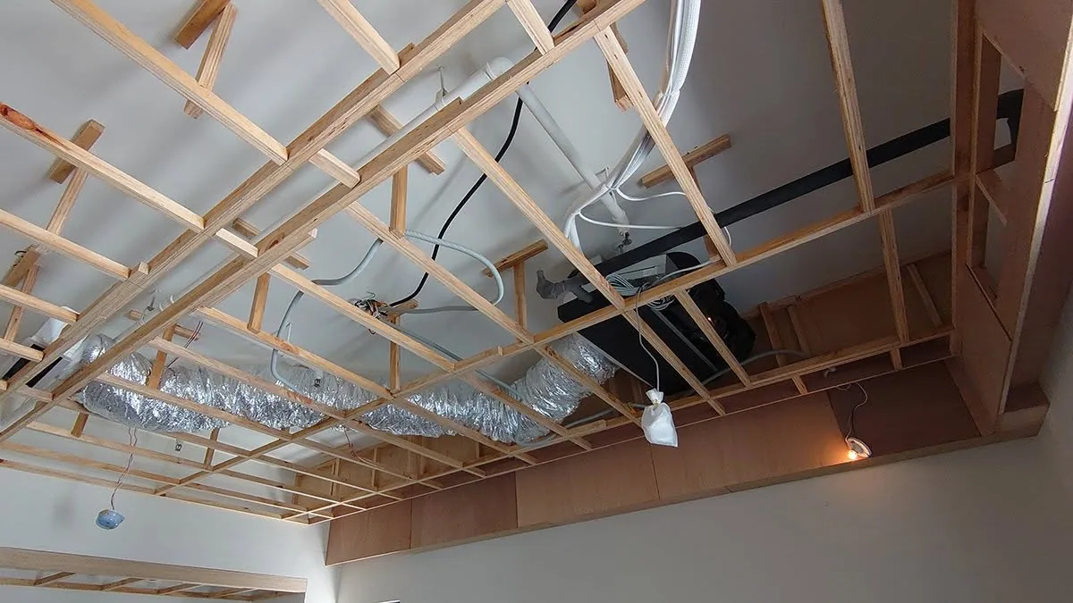 住宅翻新工程現場,工班在天花板骨架上進行木作施工