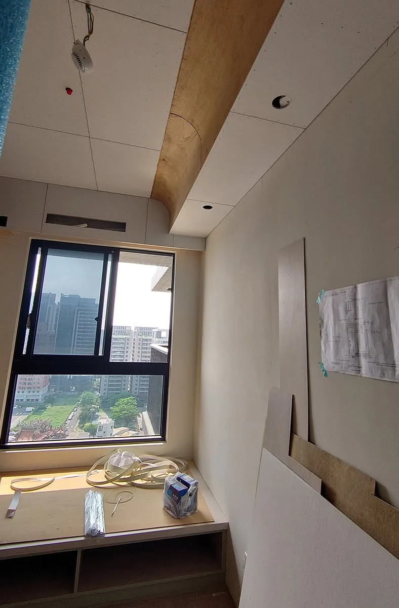 臥室天花板封板完成,窗邊臥榻櫃體施工中,牆面張貼施工圖面