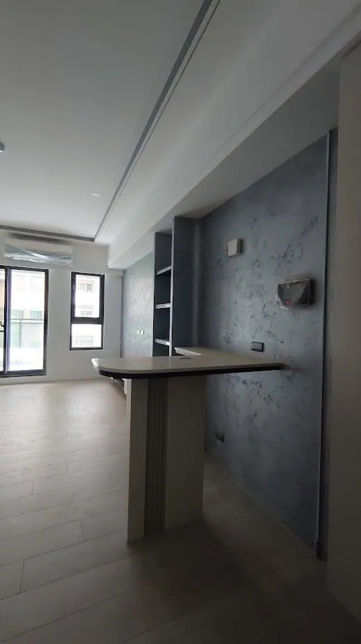 開放式公共空間完工實景，天花板保留裸露結構搭配灰階牆面與金屬燈具